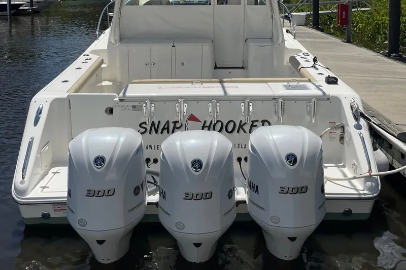 Slide: The Image of 2021 Pursuit OS 385 Offshore boat with triple Yamaha 300 engines docked at marina. - 8