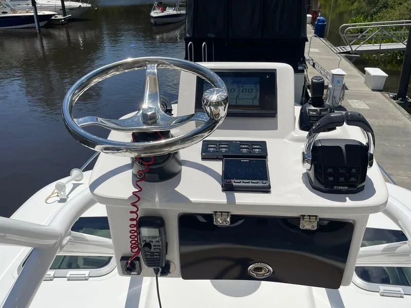 Slide: The Image of 2021 Pursuit OS 385 Offshore helm with steering wheel and navigation controls. - 9
