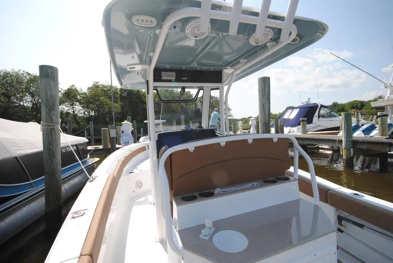 Slide: The Image of 2022 Sea Hunt Ultra 265 SE boat docked at marina, featuring spacious deck and seating. - 10