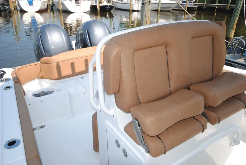 Slide: The Image of 2022 Sea Hunt Ultra 265 SE boat interior with tan seating and dual engines. - 12