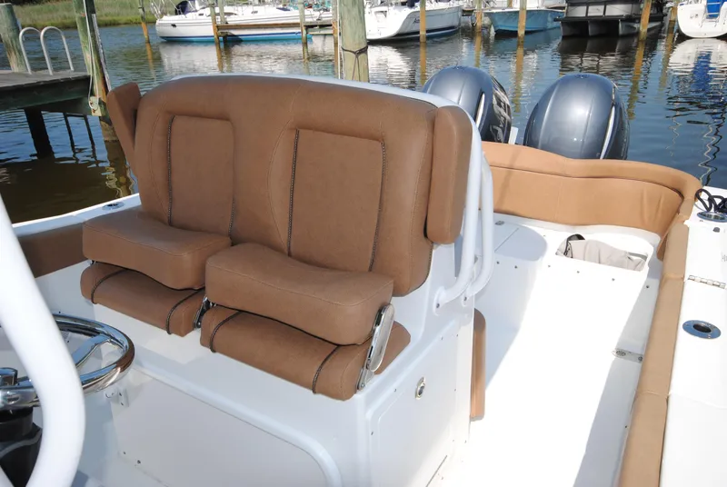 Slide: The Image of 2022 Sea Hunt Ultra 265 SE boat interior with brown seating and dual engines. - 14