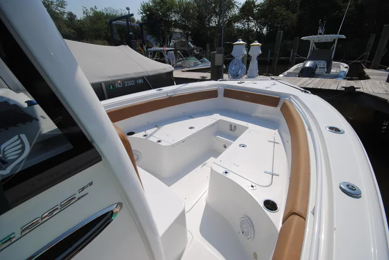 Slide: The Image of 2022 Sea Hunt Ultra 265 SE boat interior with seating and storage, docked at marina. - 17