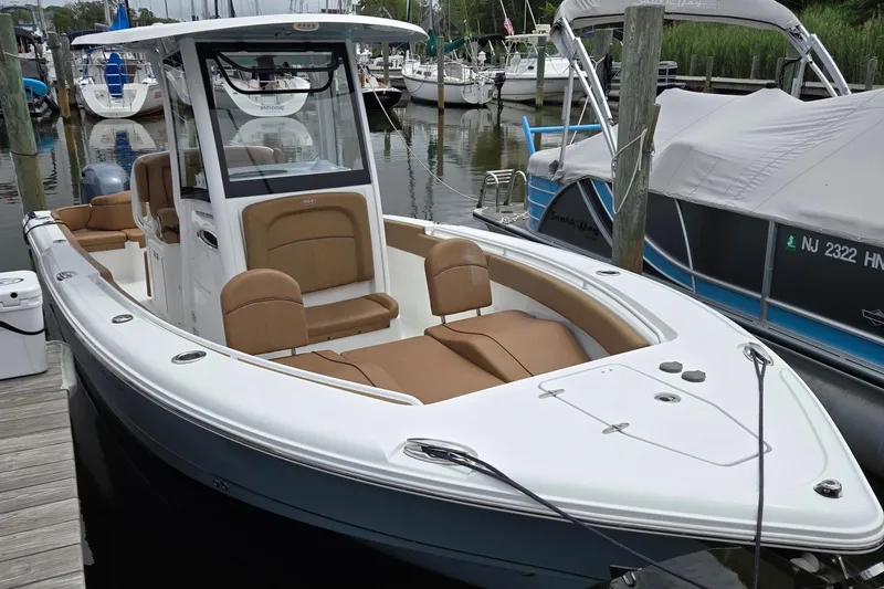 Slide: The Image of 2022 Sea Hunt Ultra 265 SE boat docked, featuring sleek design and comfortable seating. - 2