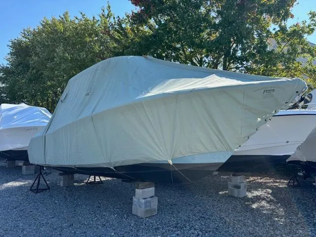 Slide: The Image of Covered 2022 Sea Hunt Ultra 265 SE boat on blocks, surrounded by trees. - 23