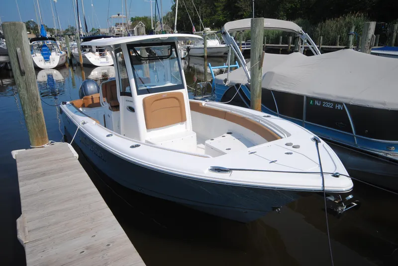 Slide: The Image of 2022 Sea Hunt Ultra 265 SE boat docked at marina, surrounded by other vessels. - 3