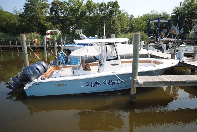 Slide: The Image of 2022 Sea Hunt Ultra 265 SE boat docked in a marina, featuring dual Yamaha engines. - 5