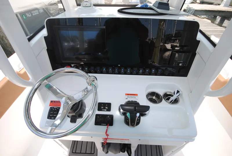 Slide: The Image of 2022 Sea Hunt Ultra 265 SE boat dashboard with steering wheel and controls. - 8