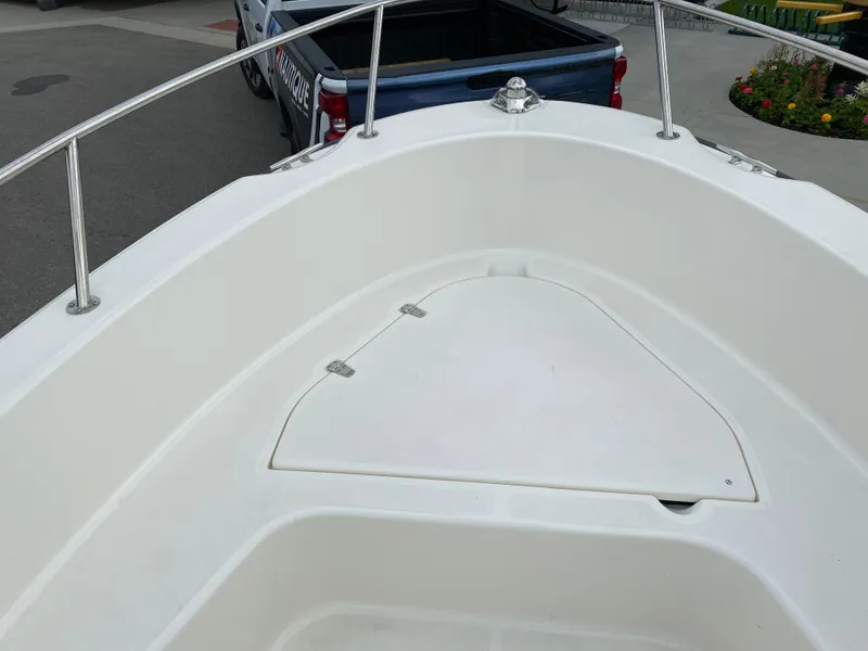 Slide: The Image of 2021 Boston Whaler 190 Outrage boat bow with storage compartment and railing. - 10