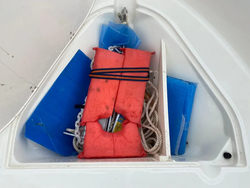 Slide: The Image of Storage compartment of 2021 Boston Whaler 190 Outrage with life jacket and ropes. - 11