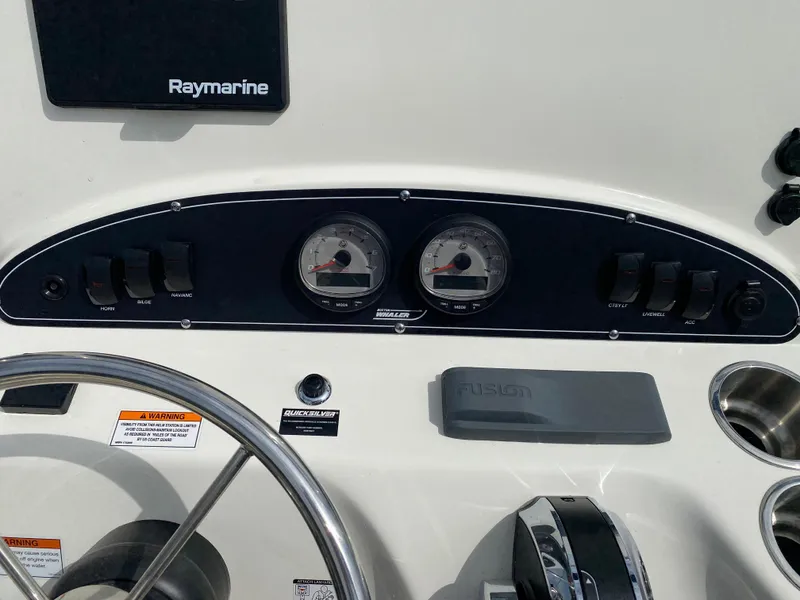 Slide: The Image of Control panel of a 2021 Boston Whaler 190 Outrage boat with gauges and switches. - 19