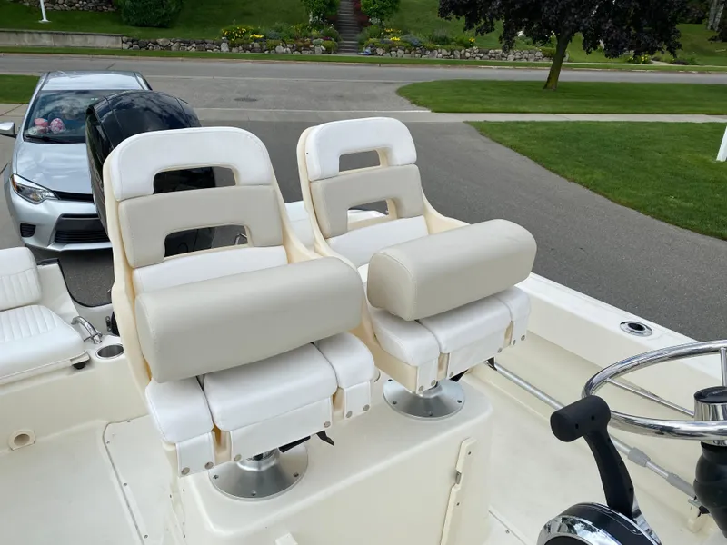 Slide: The Image of Boston Whaler 190 Outrage 2021 boat seats and steering wheel, parked near a road. - 25