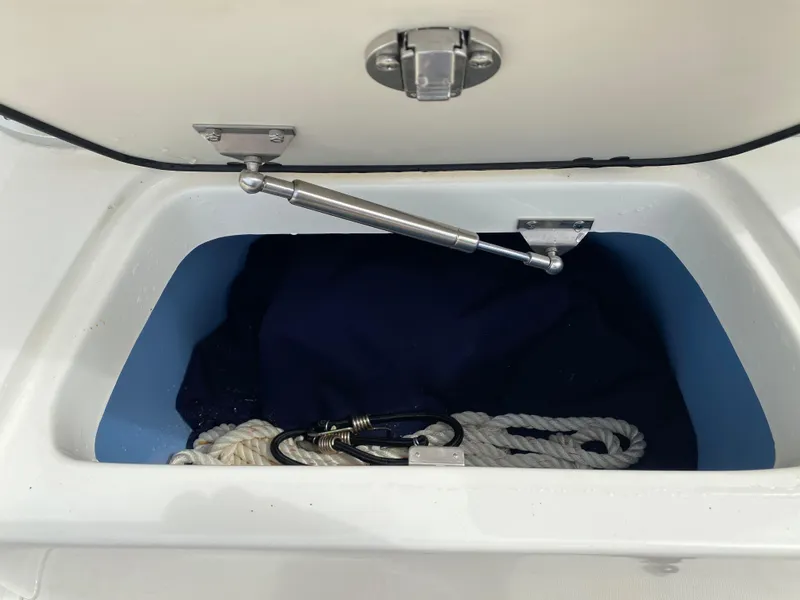 Slide: The Image of Storage compartment of a 2021 Boston Whaler 190 Outrage with rope and latch. - 27
