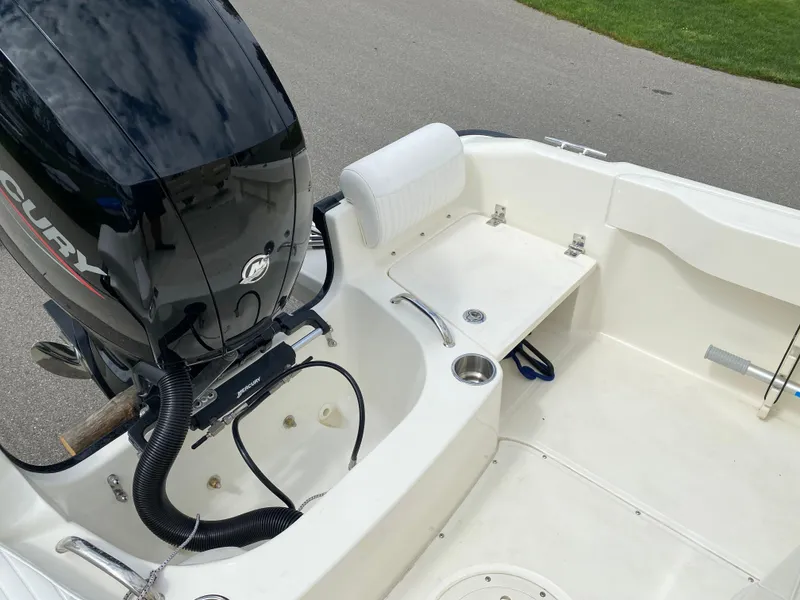 Slide: The Image of 2021 Boston Whaler 190 Outrage boat interior with Mercury engine, white seating, and storage area. - 29