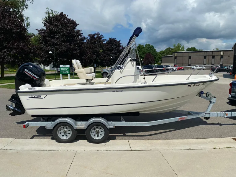Slide: The Image of 2021 Boston Whaler 190 Outrage boat on trailer, parked outdoors. - 5