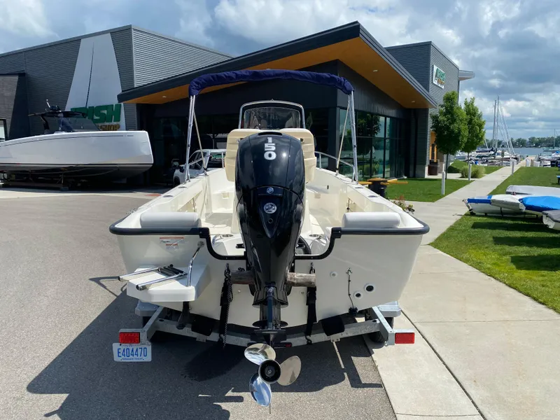Slide: The Image of 2021 Boston Whaler 190 Outrage boat with 150 HP engine, parked outside dealership. - 6