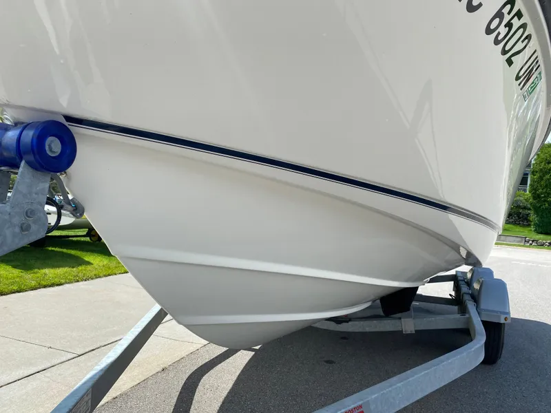 Slide: The Image of 2021 Boston Whaler 190 Outrage boat on trailer, close-up view of hull. - 9