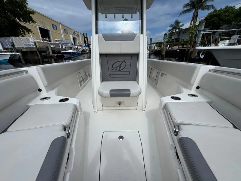 Slide: The Image of 2025 Sailfish 232 CC boat interior with seating, cup holders, and waterfront view. - 12