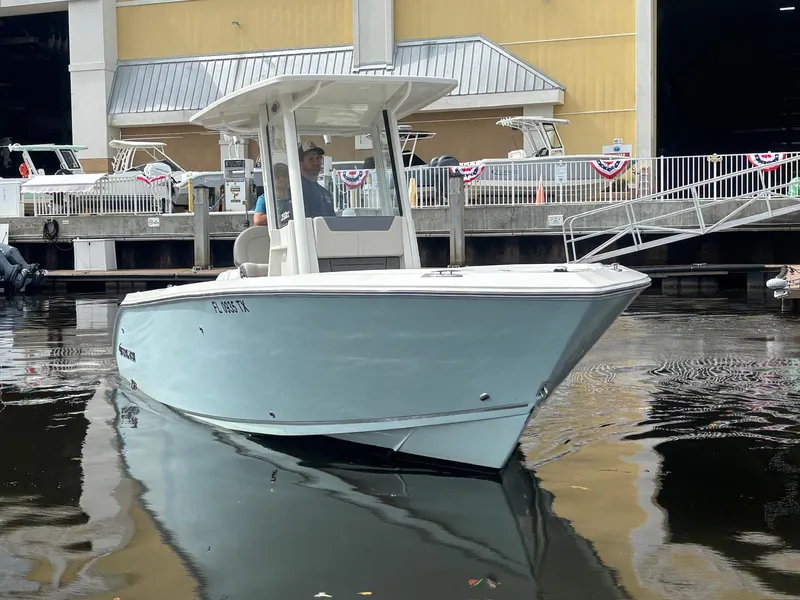 Slide: The Image of 2025 Sailfish 232 CC boat docked near a marina building. - 2