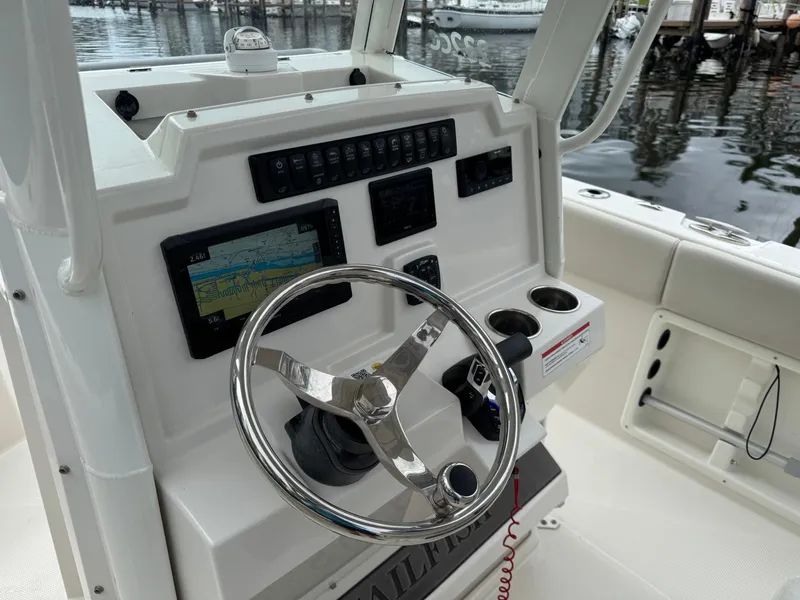 Slide: The Image of 2025 Sailfish 232 CC boat dashboard with steering wheel and navigation controls. - 6