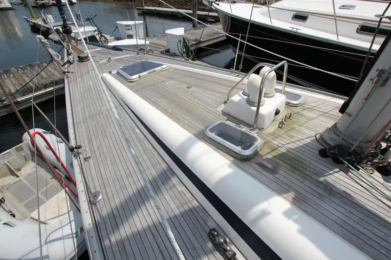 Slide: The Image of Deck of 1997 Nautor Swan 48 yacht, featuring sleek design and moored at a marina. - 8