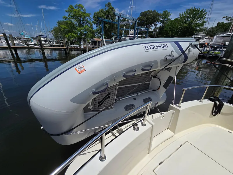 Slide: The Image of Inflatable boat mounted on a 2001 Nordic Tug 32 at a marina. - 16