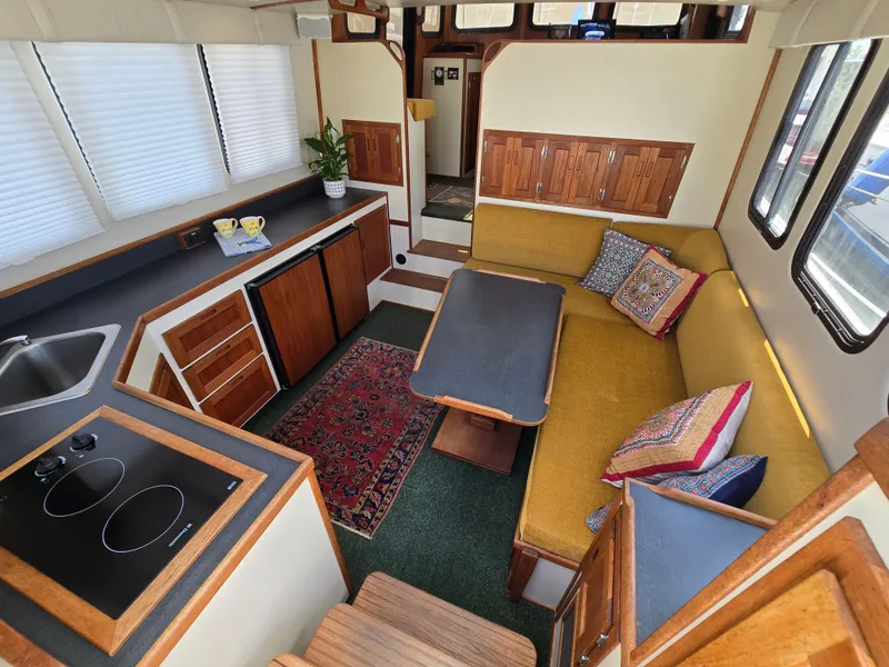 Slide: The Image of Interior of 2001 Nordic Tug 32 with cozy seating, kitchen, and decorative pillows. - 20