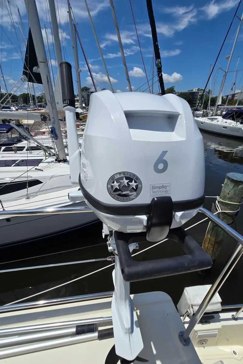Slide: The Image of Outboard motor on a 2001 Nordic Tug 32, docked with sailboats in the background. - 26