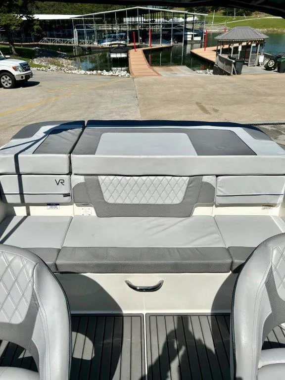 Slide: The Image of 2022 Bayliner VR4 Bowrider I/O boat interior with gray seating and dock in background. - 10