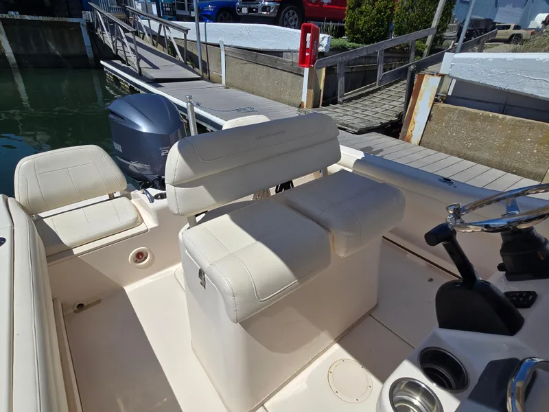 Slide: The Image of 2019 Grady-White Fisherman 216 boat interior with seating and steering wheel at dock. - 2