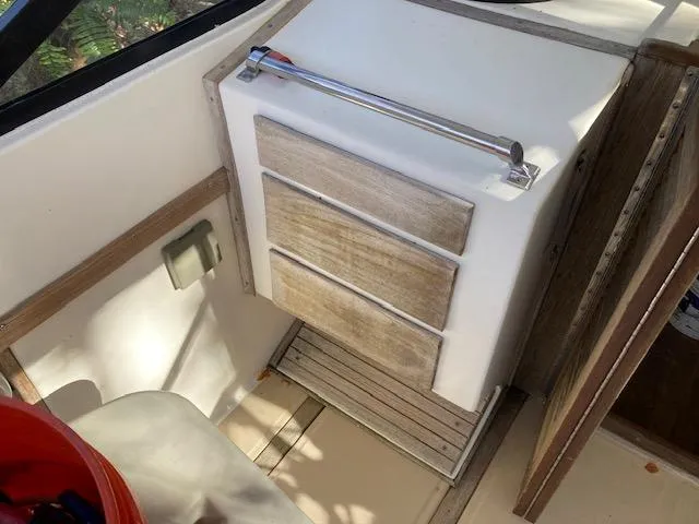 Slide: The Image of 1986 Albemarle 24 Cuddy interior with wooden storage drawers and handle. - 10