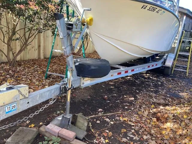 Slide: The Image of 1986 Albemarle 24 Cuddy boat on trailer, surrounded by autumn leaves. - 3