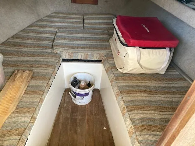 Slide: The Image of 1986 Albemarle 24 Cuddy cabin interior with striped cushions and storage. - 9