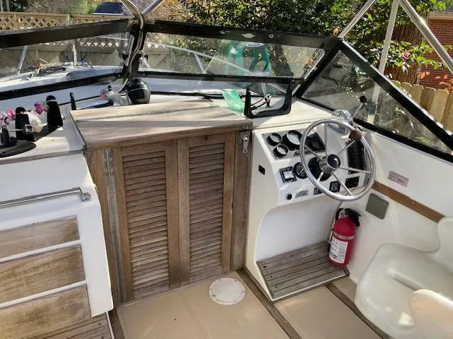 Slide: The Image of 1986 Albemarle 24 Cuddy cabin interior with striped cushions and storage. - 8