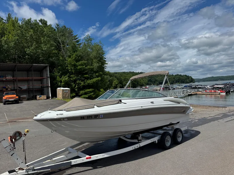 The Image of 2008 Crownline 220 LS boat on trailer by a lake under a cloudy sky. - 0