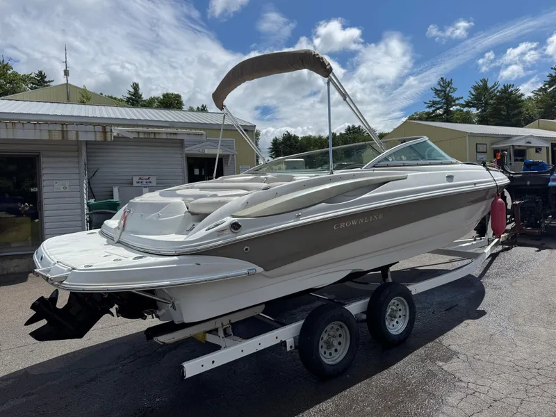 Slide: The Image of 2008 Crownline 220 LS boat on trailer, parked outside a building under a cloudy sky. - 2