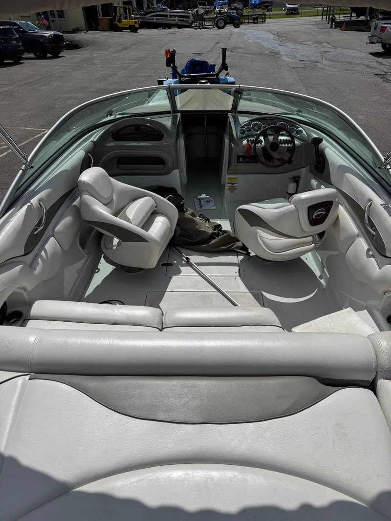Slide: The Image of 2008 Crownline 220 LS boat interior with seating and steering wheel, parked on pavement. - 4