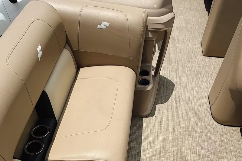 Slide: The Image of 2022 Starcraft LX22 boat interior with beige seating and cup holders. - 10