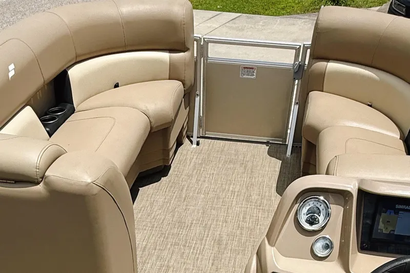 Slide: The Image of Interior of 2022 Starcraft LX22 pontoon boat with beige seating and dashboard. - 12