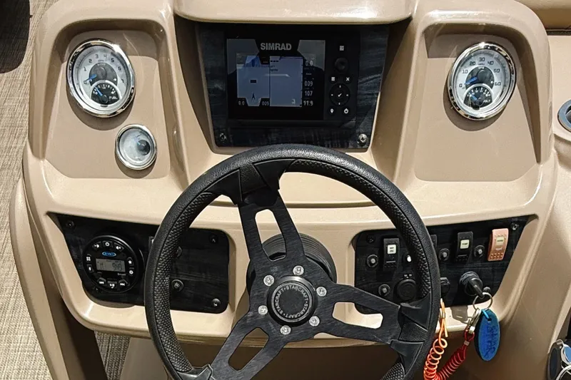 Slide: The Image of 2022 Starcraft LX22 boat dashboard with steering wheel, gauges, and Simrad display. - 13