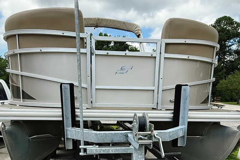 Slide: The Image of 2022 Starcraft LX22 pontoon boat on trailer, beige exterior, parked outdoors. - 27