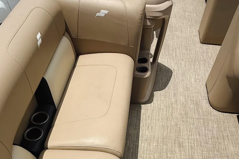 Slide: The Image of 2022 Starcraft LX22 boat interior with beige seating and cup holders. - 29
