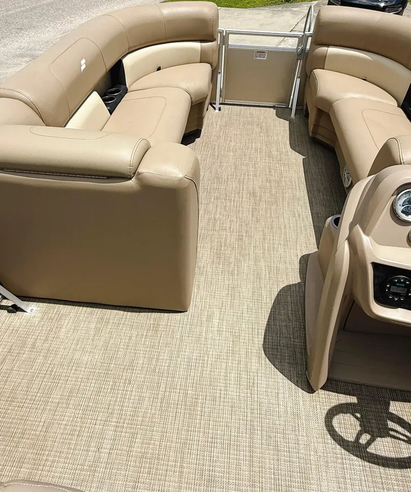Slide: The Image of 2022 Starcraft LX22 pontoon boat interior with beige seating and carpeted floor. - 34