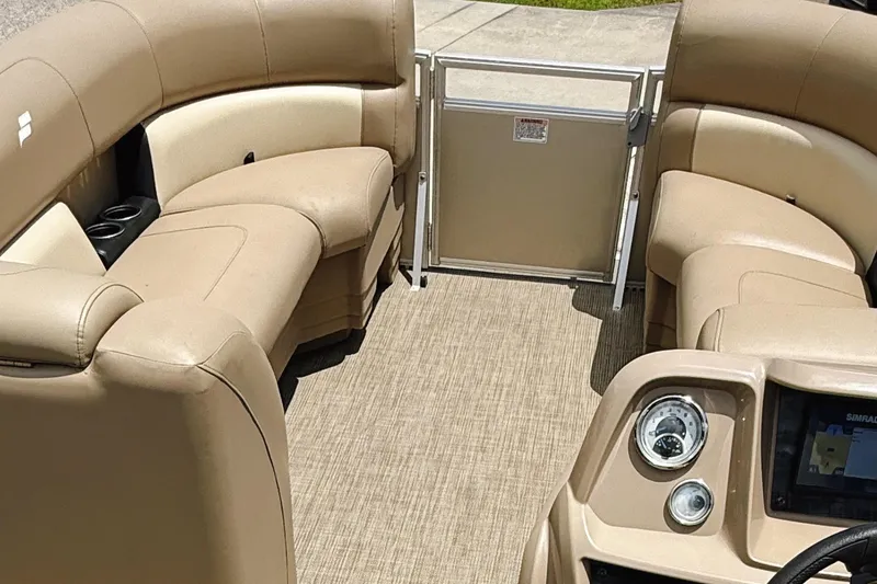 Slide: The Image of Interior of 2022 Starcraft LX22 pontoon boat with beige seating and dashboard. - 35