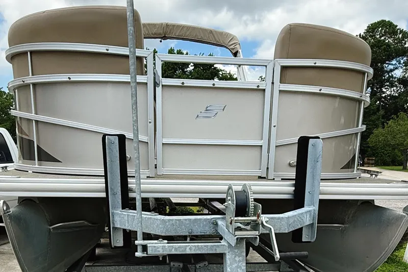 Slide: The Image of 2022 Starcraft LX22 pontoon boat on trailer, beige exterior, parked outdoors. - 5
