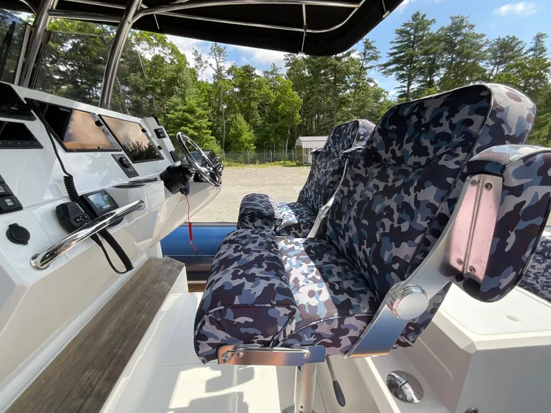 Slide: The Image of Interior of 2019 Protector 310 Chase boat with camo-patterned seats and control panel. - 17