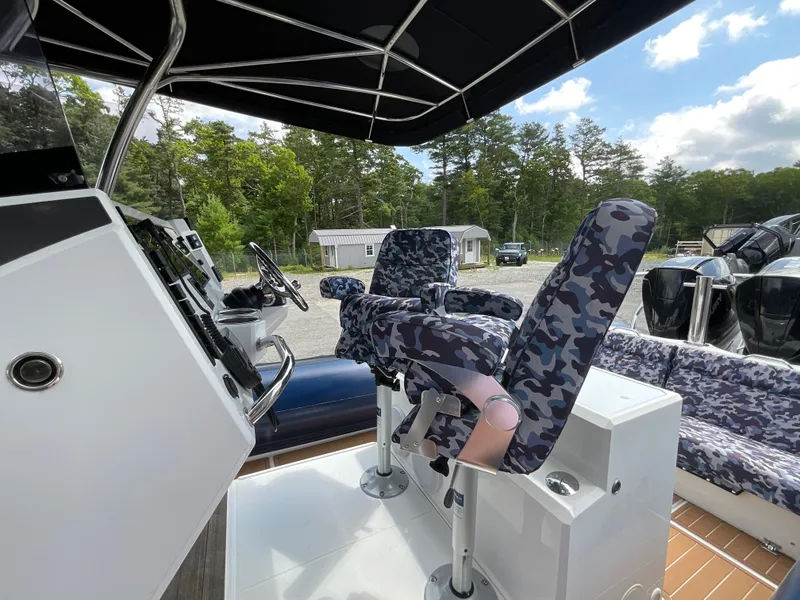Slide: The Image of 2019 Protector 310 Chase boat interior with camo seats and control panel. - 18