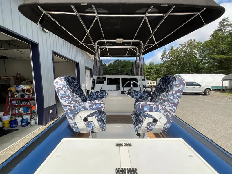 Slide: The Image of 2019 Protector 310 Chase boat interior with camo seats and steering console. - 20