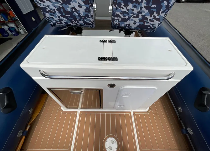 Slide: The Image of 2019 Protector 310 Chase boat interior with camo seats and wooden flooring. - 22