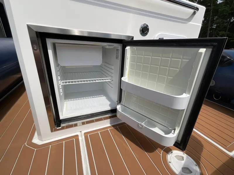 Slide: The Image of Open mini fridge on 2019 Protector 310 Chase boat deck, showing interior shelves. - 25