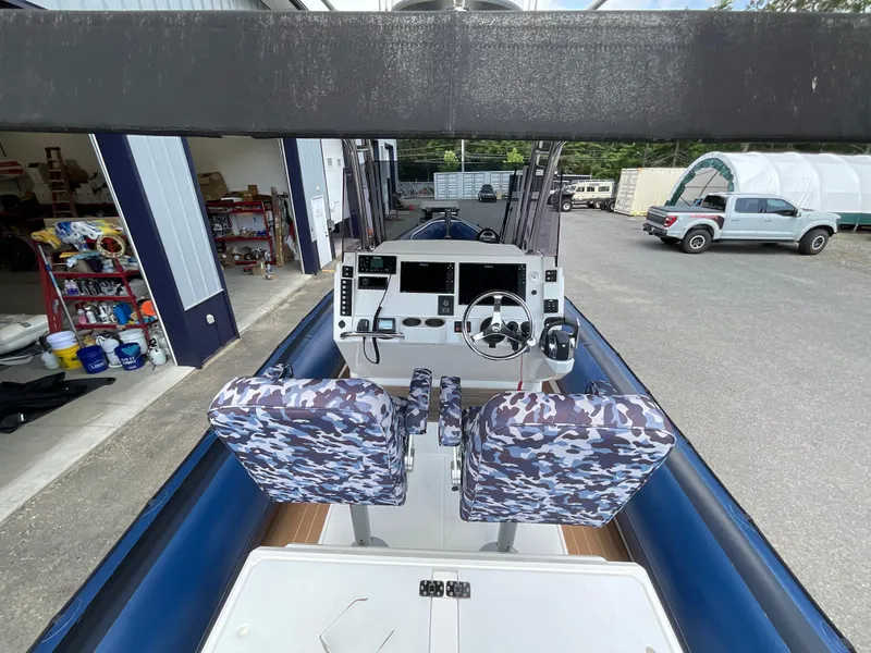 Slide: The Image of 2019 Protector 310 Chase boat interior with camo seats and modern control panel. - 32